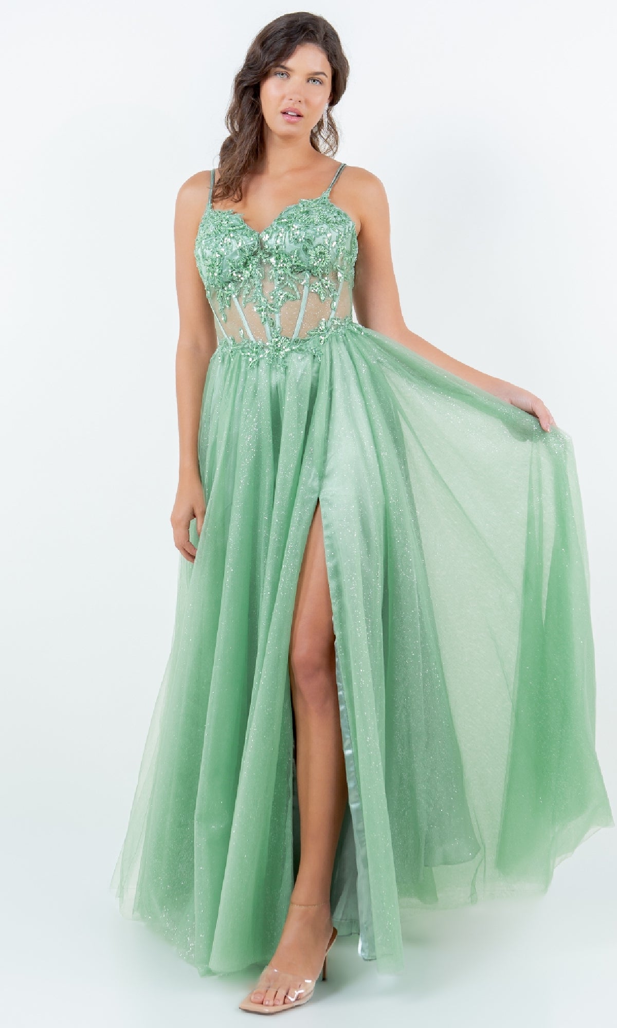 A woman models the Long Glitter Prom Dress Cinderella Couture 8238J, a sleeveless light green semi-sheer A-line gown with floral embellishments, sequin lace embroidery, and a high slit, against a plain white background.